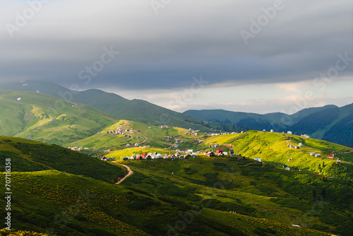 The highland Georgian village of Gomismta at dawn. Georgia travel destination. Mountain landscape of the Caucasus with fresh green meadows and mountain peaks in the background. 