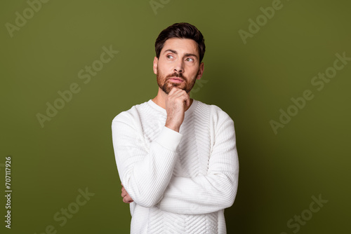 Photo of handsome serious man wear stylish white pullover look empty space solving dilemma isolated on khaki color background