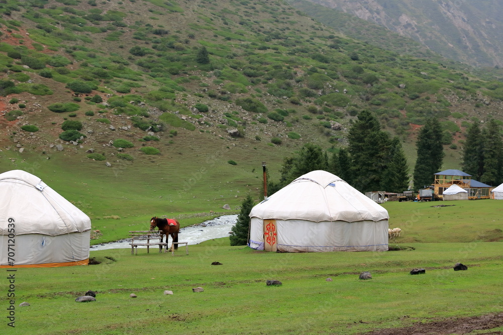 landscape near Jeti Oguz gorge with yurts and green meadows on a cloudy day