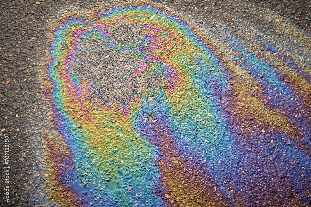 Texture of colorful petrol oil spill on wet pavement