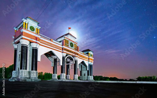 City arch at the entrance to Jalal-Abad city on a moonlit night, Kyrgyzstan. photo
