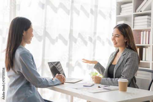 Asian businesswoman is discussing a new business project on a tablet. In a meeting, two people discuss investment projects on data charts and planning strategies. About new business