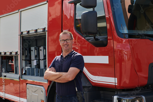 Confident firefighter stands with crossed arms, exuding resilience and preparedness, ready to respond to emergencies alongside a modern fire truck, showcasing the heroism and strength of the fire