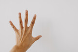 Image of woman's hand showing numbers five, counting fingers gesture, back hand, touching stop isolated on white background wall. 