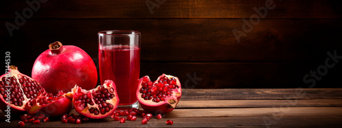 pomegranate juice on a wooden table on a dark background. photo