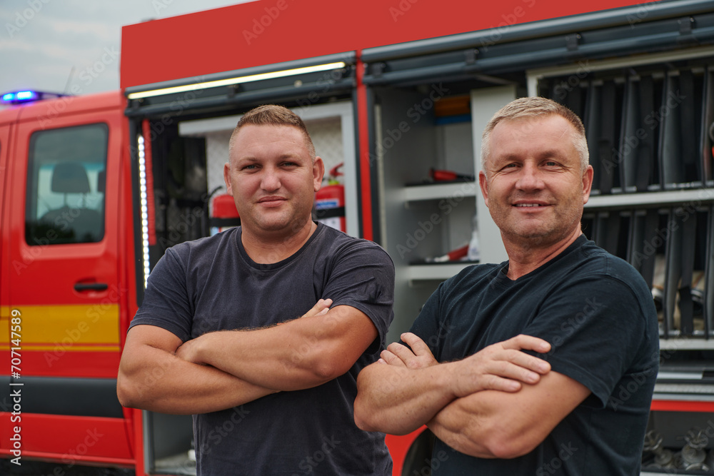 A skilled and dedicated professional firefighting team proudly poses in front of their state of the art firetruck, showcasing their modern equipment and commitment to ensuring public safety. A skilled and dedicated professional firefighting team proudly poses in front of their state of the art firetruck, showcasing their modern equipment and commitment to ensuring public safety.