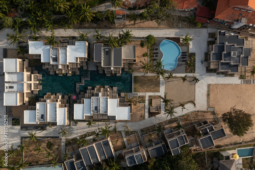 Top down aerial shot of resort  in golden morning light with swimming pools, beach, buildings and gardens.  A popular resort town in Vietnam know for windsurfing and kite surfing