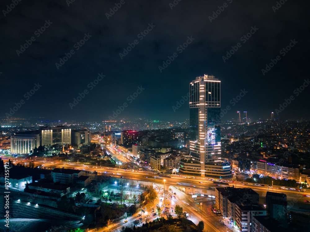 Fototapeta premium Istanbul's glass and concrete skyscrapers, home to offices, hotels, and residential complexes at night. Aerial drone view