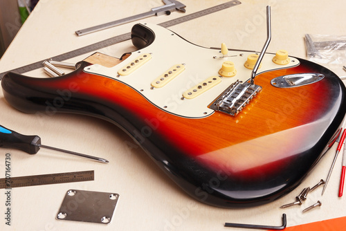 Body of electric guitar at workplace of guitar technician. photo