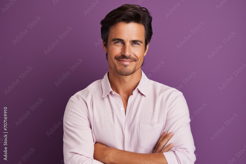 Portrait of handsome young man with crossed arms against purple background. Portrait of handsome young man with crossed arms against purple background.