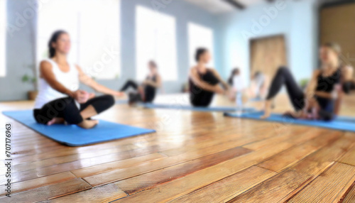 Young people practicing yoga in gym, focus on foreground, blurred background