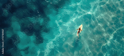 Woman swimming alone in clear ocean water. Solitude and tranquility.