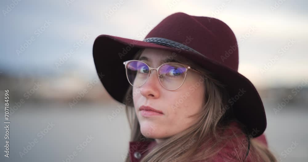 Young woman wearing glasses and a stylish hat, close up shot, subtle smile, shallow depth of field Young woman wearing glasses and a stylish hat, close up shot, subtle smile, shallow depth of field