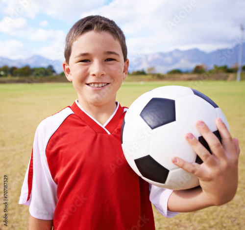 Child, portrait and happy soccer player on field, sports and confidence for match and game. Boy, face and ready for competition in outdoors, smiling and practice or training for skill development © M Moller/peopleimages.com