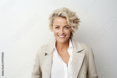 Portrait of happy mature businesswoman smiling at camera over white background