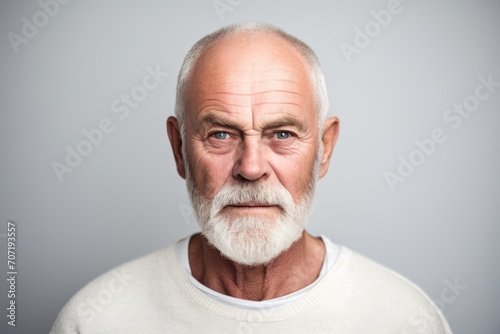 Portrait of an old man with a white beard on a gray background