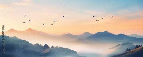 view of the mountains in the morning with light mist and birds flying
