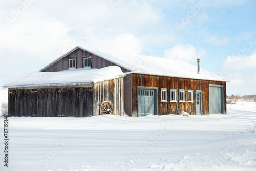 Large barn clad in old wood and metal seen during an sunny winter morning, St. Augustin de Desmaures, Quebec, Canada