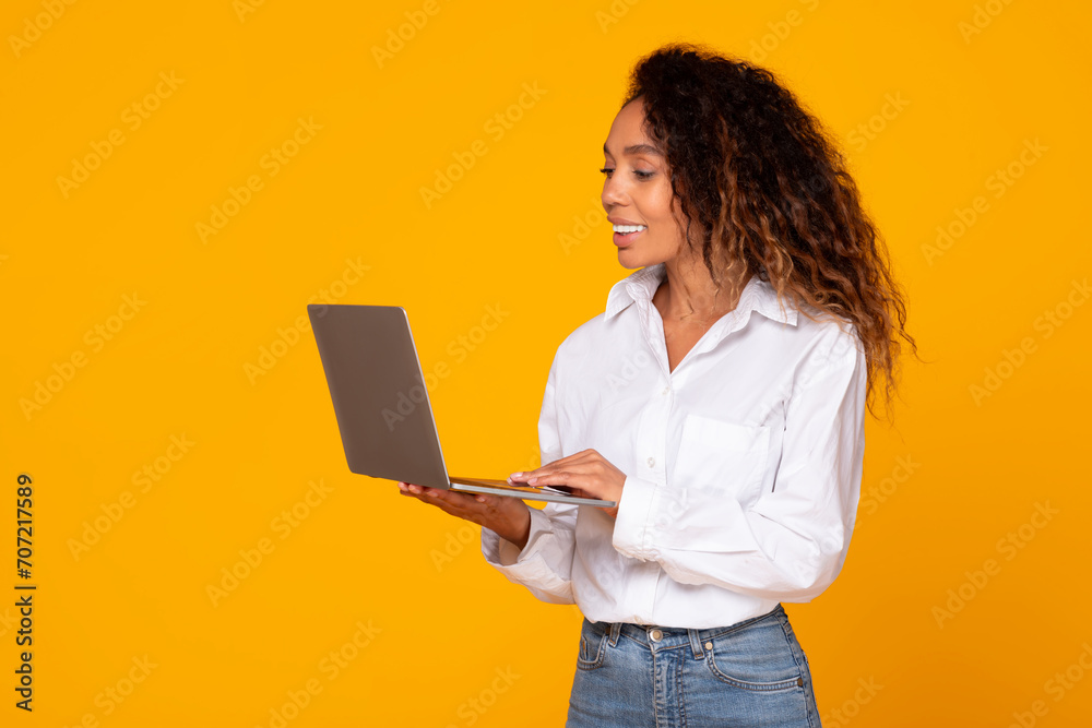 black woman holding and using laptop working online in studio black woman holding and using laptop working online in studio