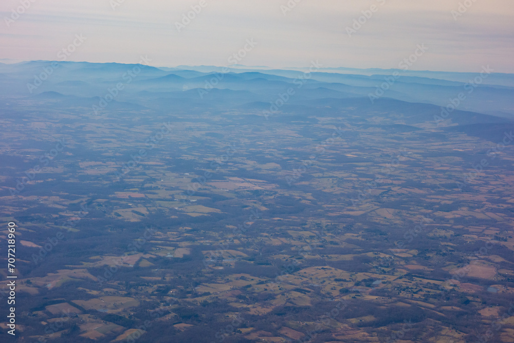 Rural Virginia with the Blue Ridge Mountains in the background, seen from high above through a plane window.