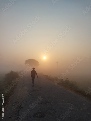 PHOTO OF A PERSON WALKING ON STREET IN FOG