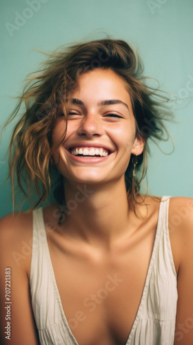 Closeup portrait of a smiling young woman with hair in the wind