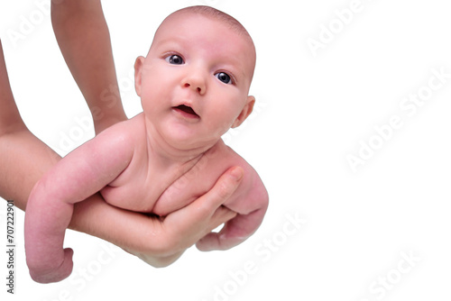 Mom trains swimming with a happy infant baby boy in a home bath, isolated on a white background. A smiling child swims n the bathroom in the hands of his mother. Kid aged two months