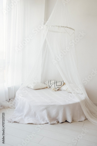 Bright stylish interior of the bedroom with a round bed and pillows. Minimalism. © Dasha Petrenko