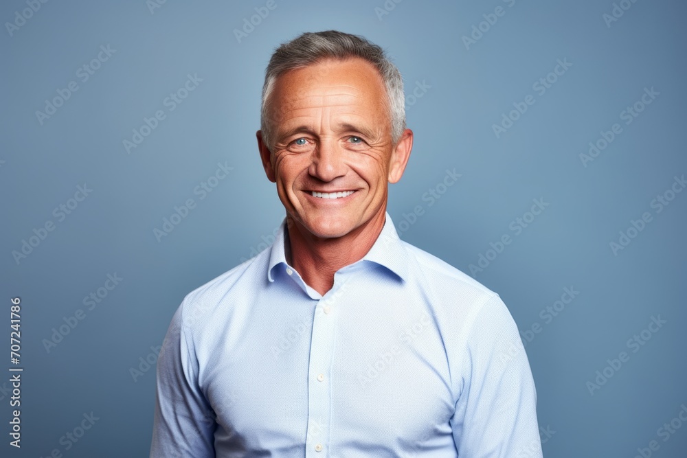 Portrait of a smiling senior man in a shirt on a blue background. Portrait of a smiling senior man in a shirt on a blue background.