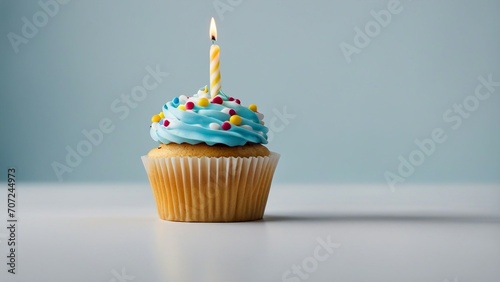 cupcake with candle A realistic scene of a birthday cupcake with a colorful single candle on a white background.  