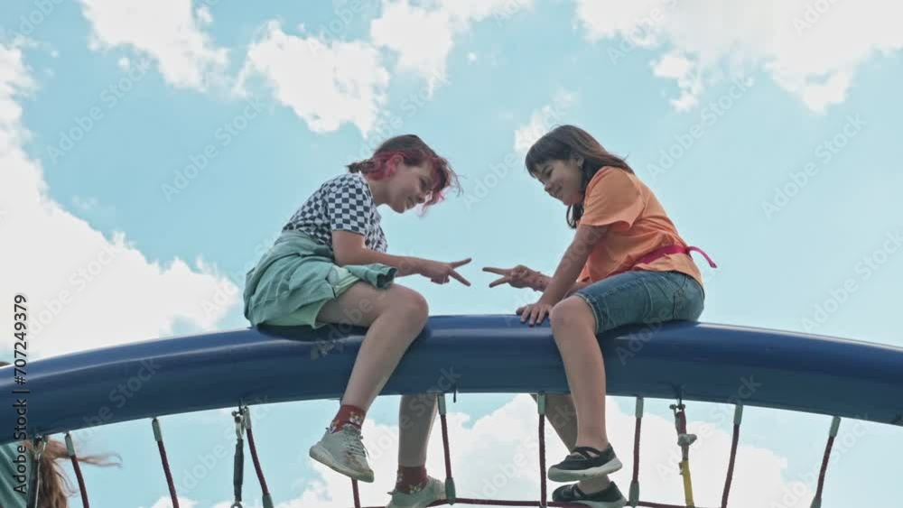 portrait of two teenage girls 11 years old chatting and laughing in the park on a walk on the playground. High quality 4k footage portrait of two teenage girls 11 years old chatting and laughing in the park on a walk on the playground. High quality 4k footage