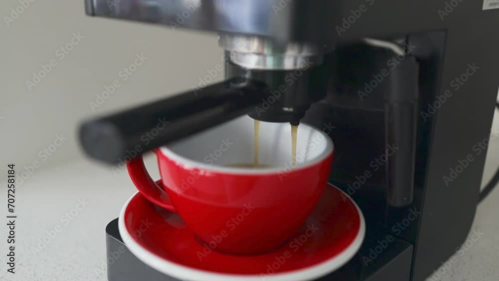 Making coffee with espresso machine in a red ceramic cup in the kitchen. High quality FullHD footage Making coffee with espresso machine in a red ceramic cup in the kitchen. High quality FullHD footage