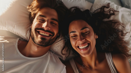 Happy couple, bed and laughing in relax for morning, bonding or intimate relationship at home. Interracial man and woman smiling with laugh in joyful happiness or relaxing weekend together © Lansk