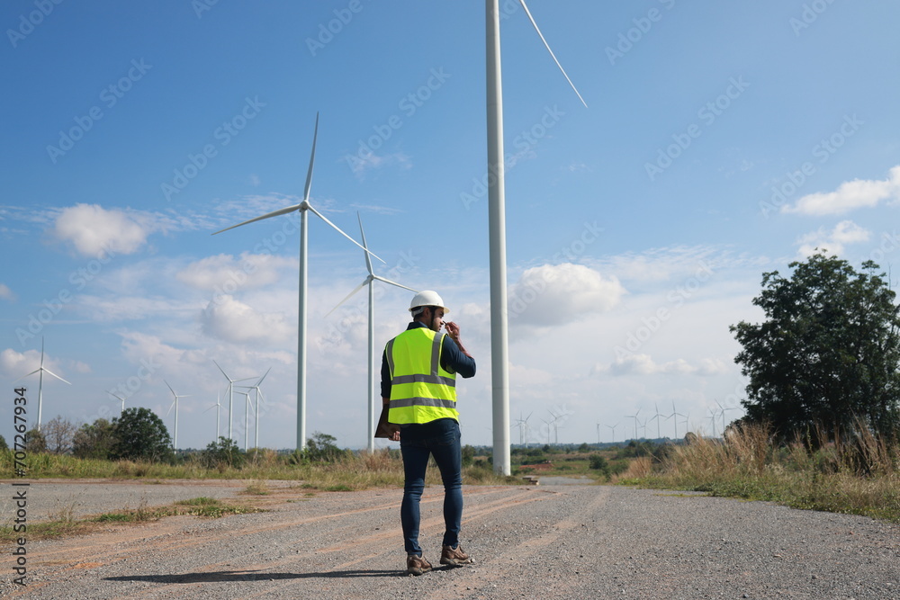 Blue collar worker at electricity site. Windmill farm Blue collar worker at electricity site. Windmill farm
