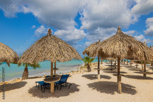 Beautiful view of Aruba's landscape with sandy Eagle Beach along the Caribbean Sea, equipped with sun umbrellas. © Alex