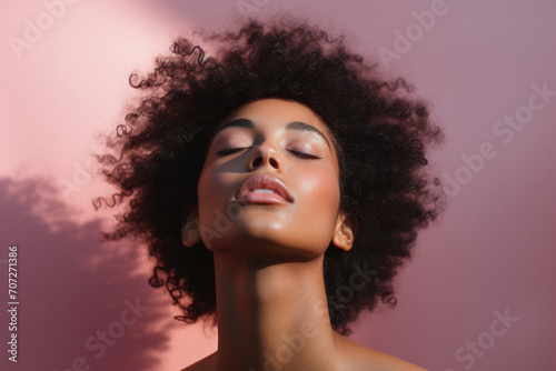Beautiful african american woman with closed eyes on pink background