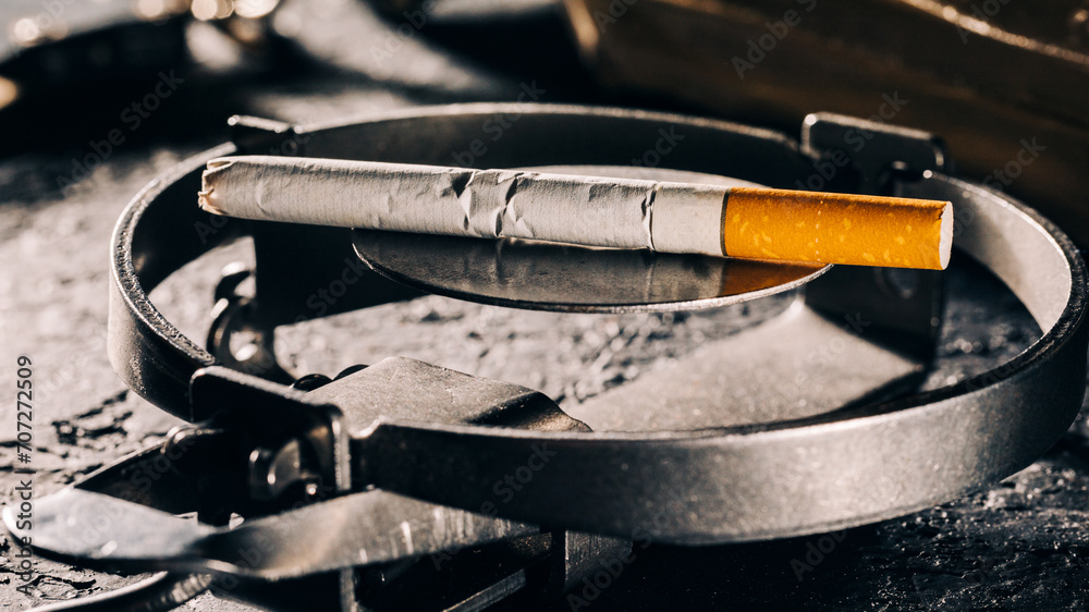 A conceptual view of smoking, represented by a cigarette as a bait in a trap. A conceptual view of smoking, represented by a cigarette as a bait in a trap.