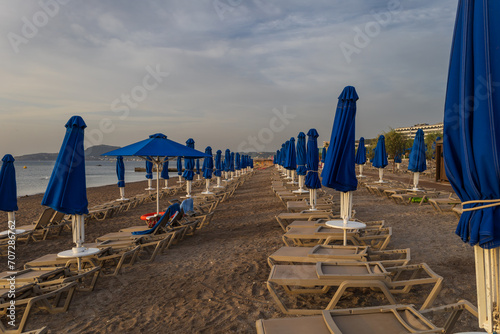Beach by the sea on the island of Rhodes in Greece. Parasols and sunbeds on the beach.