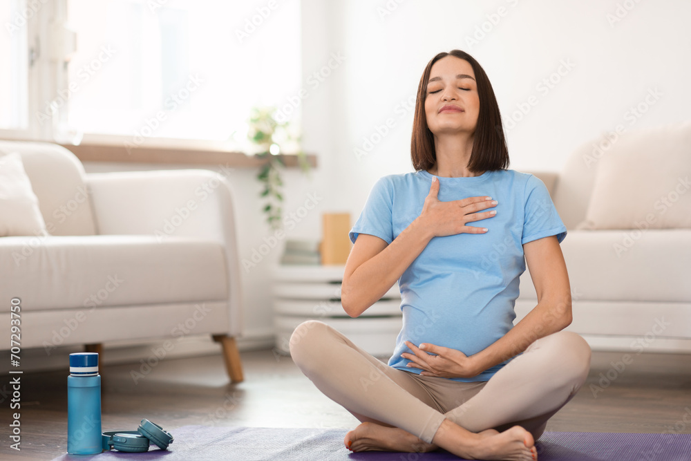 pregnant lady practicing yoga at home meditating focusing on breath pregnant lady practicing yoga at home meditating focusing on breath