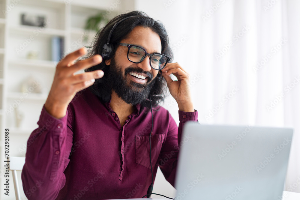 Web Conference. Smiling Indian Man In Headset Making Video Call Via Laptop Web Conference. Smiling Indian Man In Headset Making Video Call Via Laptop