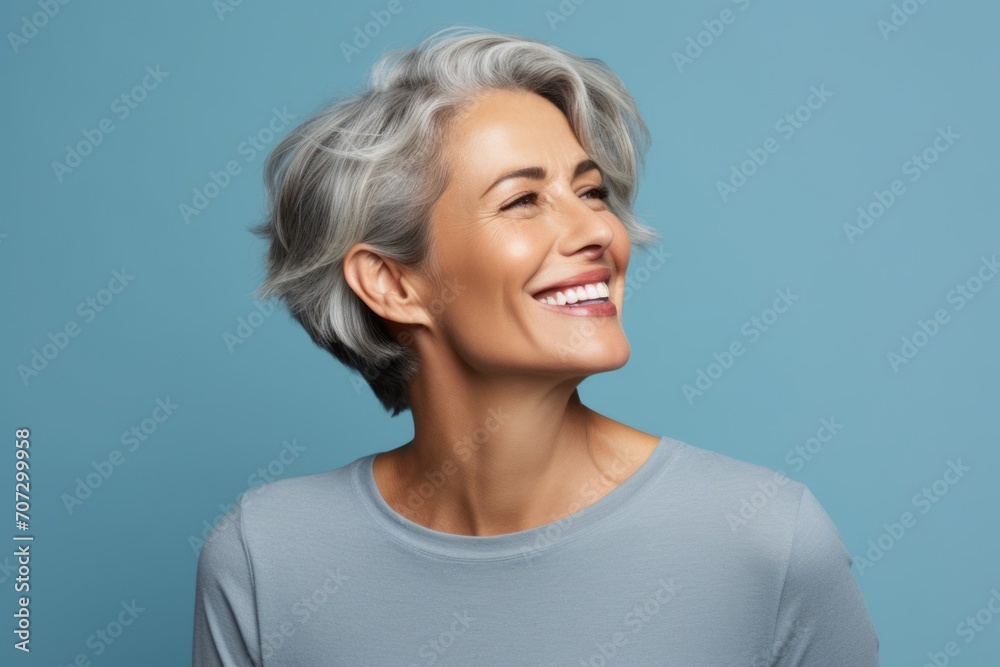 Close up portrait of beautiful smiling mature woman with grey hair, isolated over blue background Close up portrait of beautiful smiling mature woman with grey hair, isolated over blue background