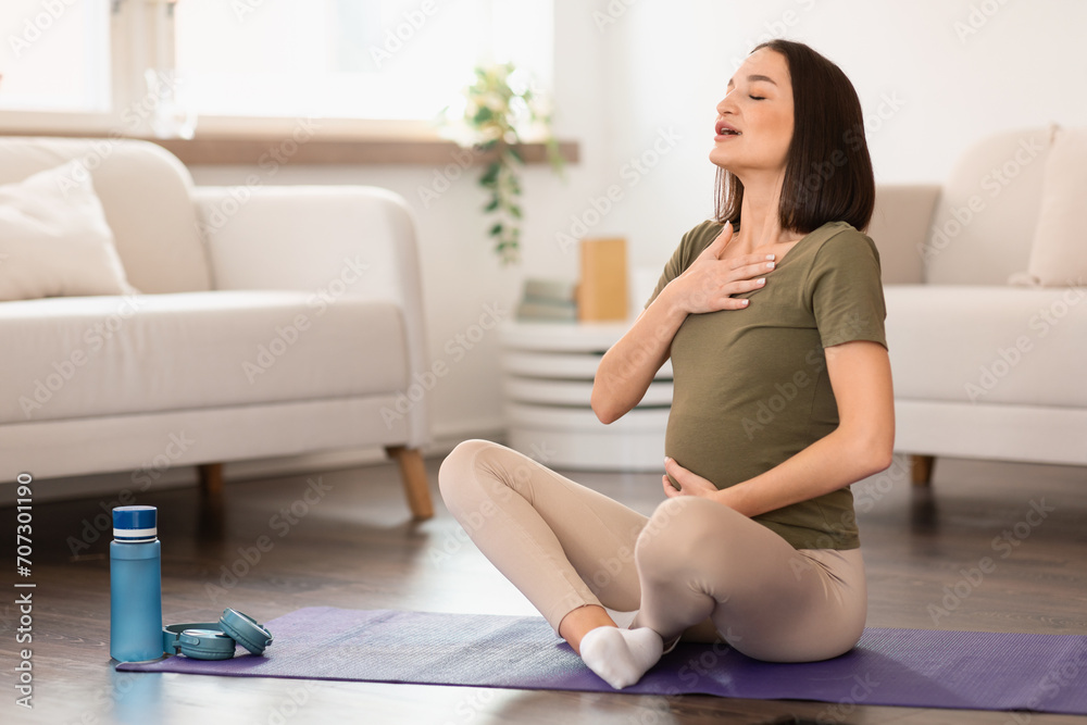 Pregnant european lady engages in meditation and breathing exercise indoor Pregnant european lady engages in meditation and breathing exercise indoor