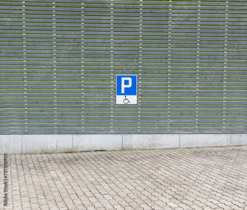 Disabled parking lot with blue traffic sign, blue and white, only people with a physical disability may park here, during the day without people