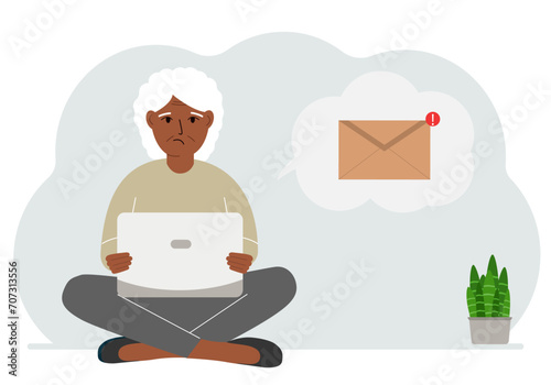 A woman sits cross-legged working with a laptop and opens an email. The concept of education, work, correspondence.