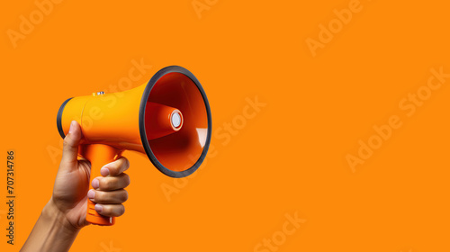 Hand man holding megaphone on orange background. Marketing and sales concept. photo
