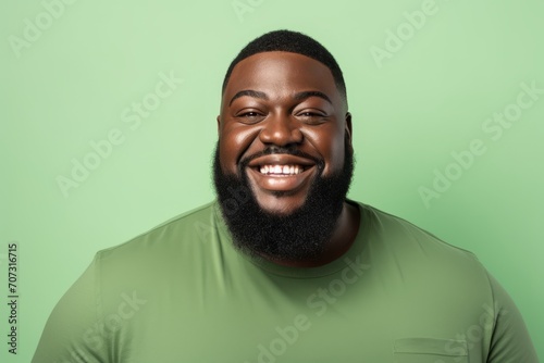 Cheerful african american man with long black beard on green background