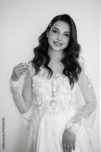 brown-haired girl puts on a wedding dress
