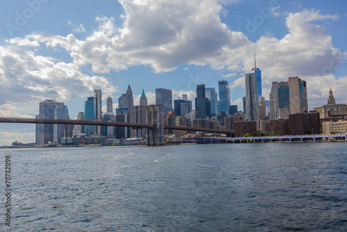 Stunning view of Manhattan skyscrapers from the Hudson River against a backdrop of blue sky with drifting white clouds on a sunny summer day. USA.