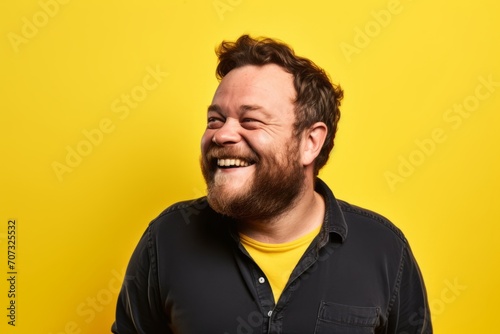 Portrait of a funny man laughing over yellow background. Emotions concept.