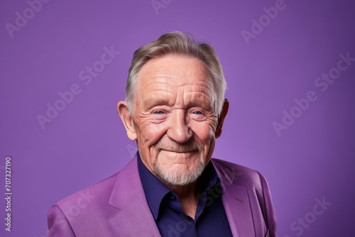 Portrait of a happy senior man. Isolated on purple background. © Iigo